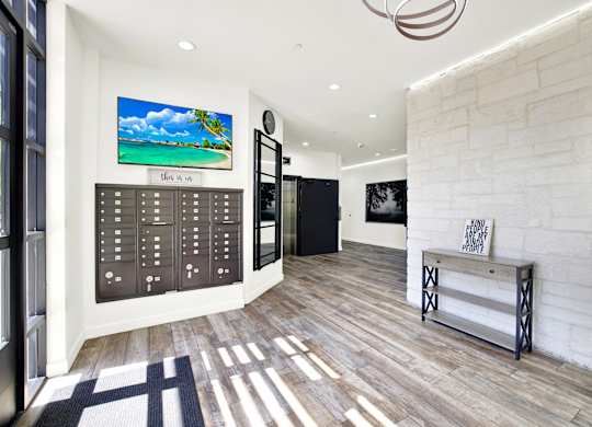 A modern interior with a wooden floor and a large painting of a beach scene on the wall.