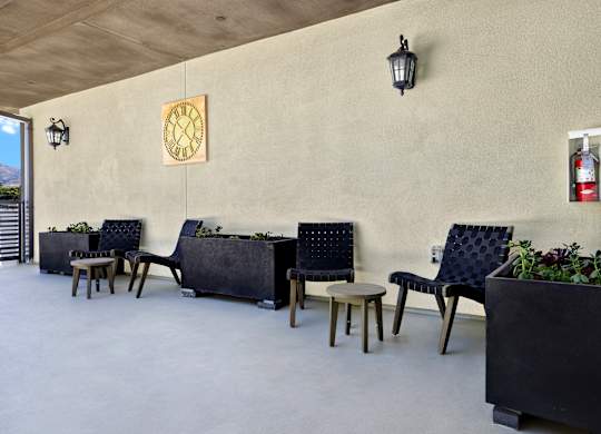 A row of black chairs with wooden legs are lined up against a wall.