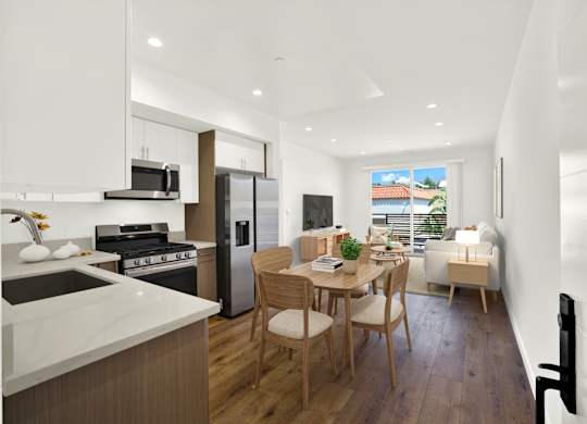 A modern kitchen with a dining table and chairs.