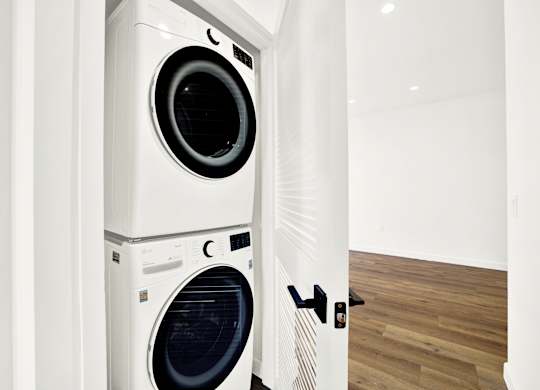 A white washing machine and dryer in a small room.