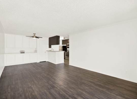 A room with a ceiling fan and a kitchen area at Monterra Ridge Apartments, Canyon Country, California