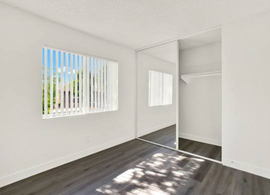 A room with a white wall and a wooden floor at Monterra Ridge Apartments, Canyon Country
