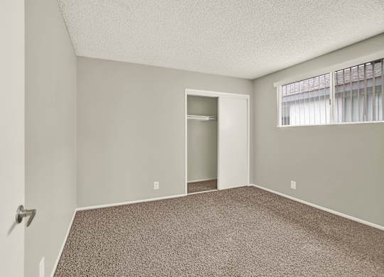 A room with a carpeted floor and a doorway leading to another room at The Square in Downey, CA, 90242