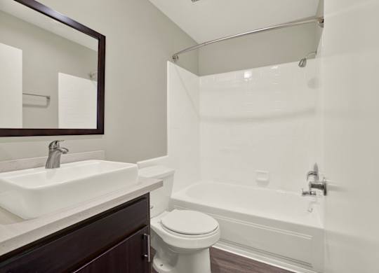 A white sink is on a brown countertop in a bathroom at The Square in Downey, CA, 90242