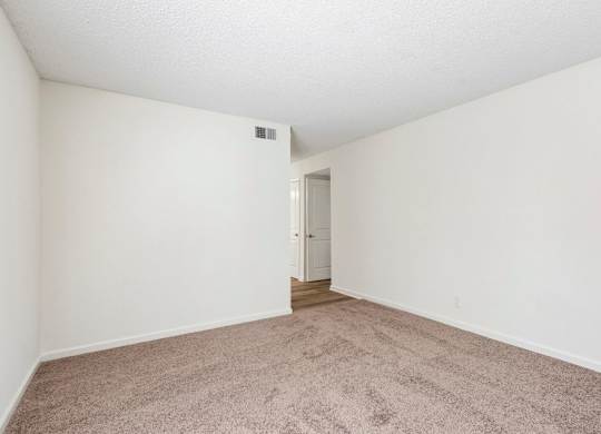 A room with a carpeted floor and a door in the middle.