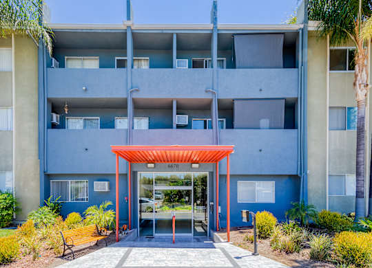 A blue building with a red canopy and a glass door.