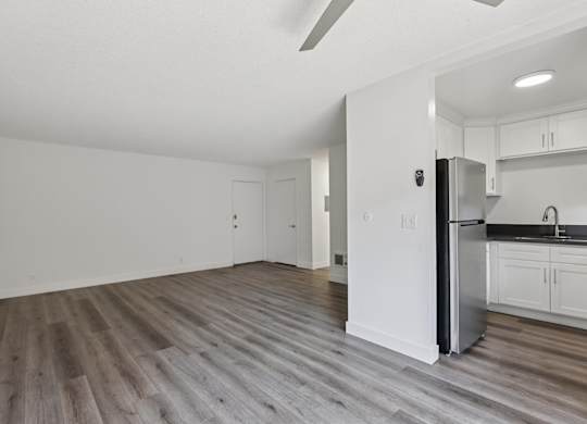 A kitchen with white cabinets and a refrigerator.