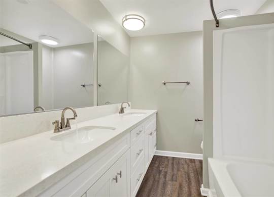 Dual sink bathroom with white vanity and wood style flooring at Parc @ 5 Apartments, California