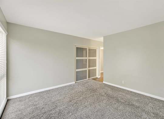 Empty bedroom with frosted glass sliding doors at Parc @ 5 Apartments, Downey, CA 90240