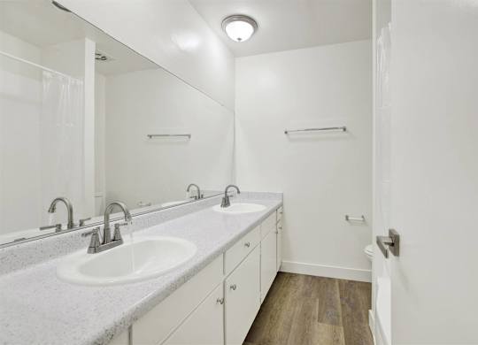 Bathroom with double vanity and large mirror at Parc @ 5 Apartments, Downey, CA 90240
