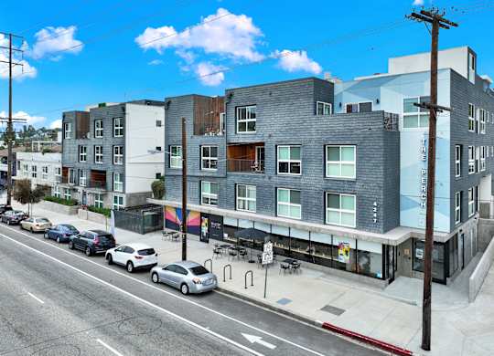 an apartment building on a city street with cars at the perch, Los Angeles California