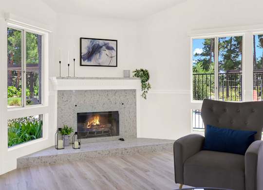 a living room with a fireplace and a chair at Monterra Ridge Apartments, California,91351