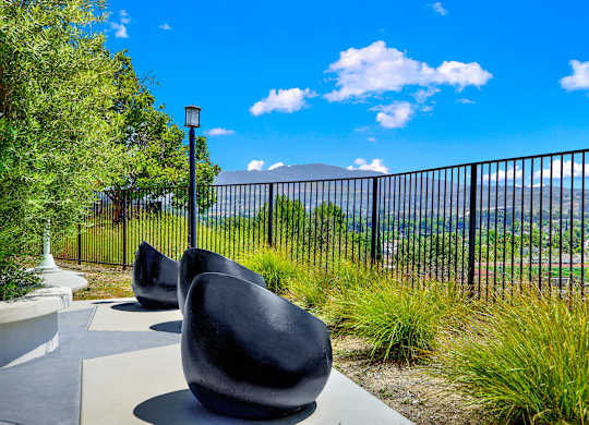 a group of chairs sitting in front of a fence at Monterra Ridge Apartments, Canyon Country ,91351