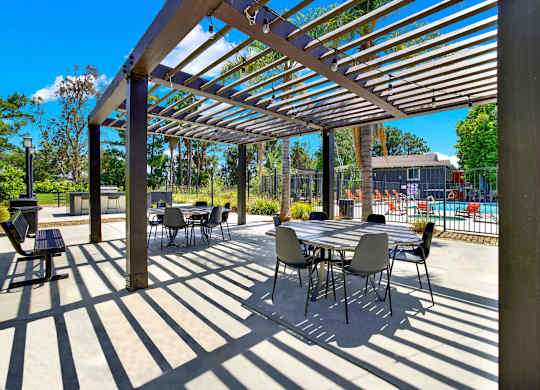a patio with tables and chairs under awning at Monterra Ridge Apartments,California