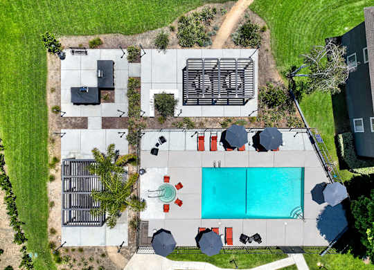 arial view of the pool and yard of a house with a blue pool at Monterra Ridge Apartments, Canyon Country ,91351