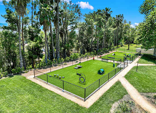 a tennis court in a park with trees at Monterra Ridge Apartments,California