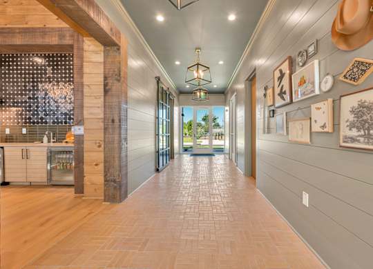 A long hallway with a tile floor and pictures on the wall.