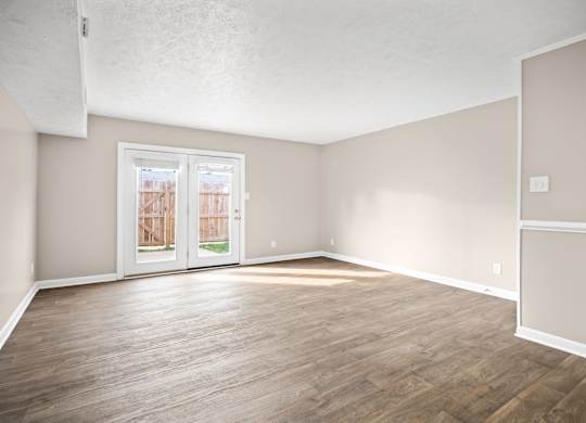 Empty room with wooden floors and white walls.
