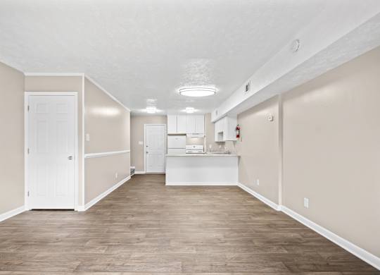 A large empty room with wooden floors and white walls.