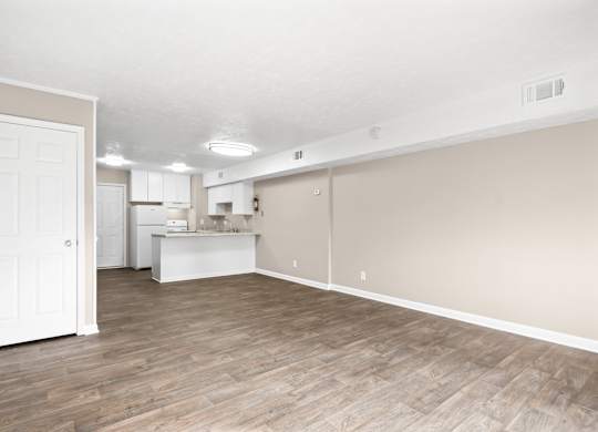 A room with wooden flooring and white walls.