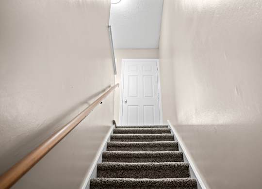 A staircase with a white door at the top.