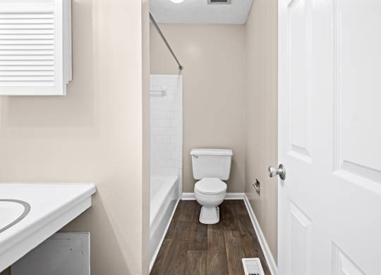 A white toilet in a small bathroom with a white door.
