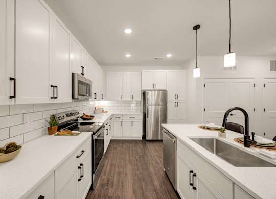 A modern kitchen with white cabinets and a stainless steel refrigerator.