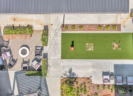 A green lawn with a person playing cricket.