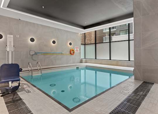 A small indoor pool with a blue chair.