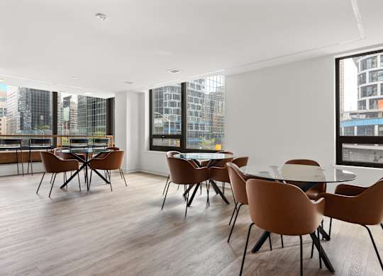 A conference room with brown chairs and a long table.