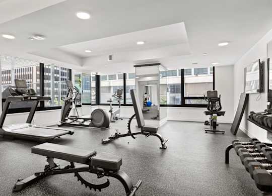 A spacious gym with a variety of equipment including treadmills, weights, and exercise machines.