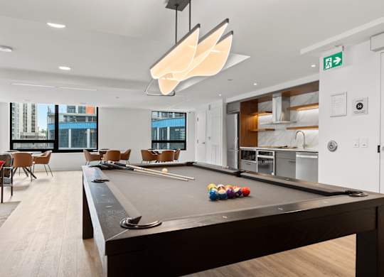 A pool table in a room with a view of the city.