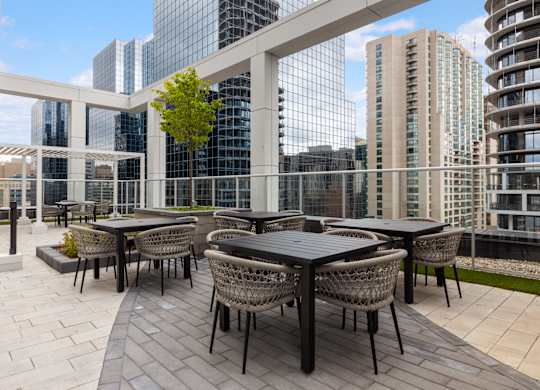 A patio with a table and chairs overlooking a cityscape.