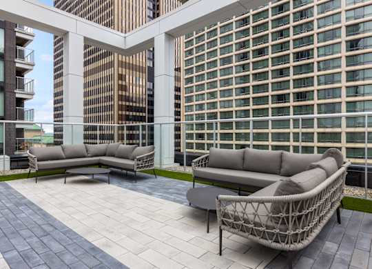A patio with a white couch and a black table.