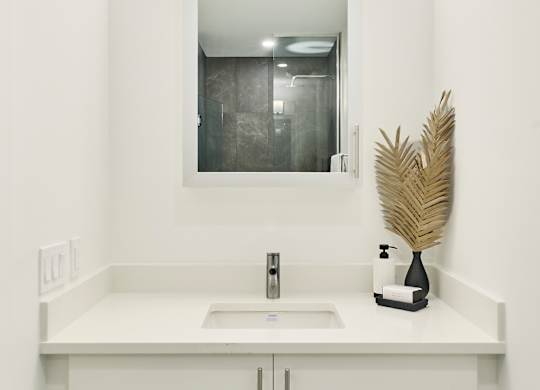 a white bathroom with a sink and a mirror