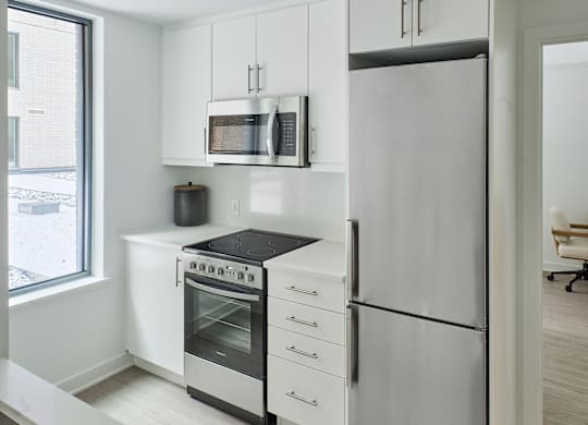 a kitchen with white cabinets and stainless steel appliances
