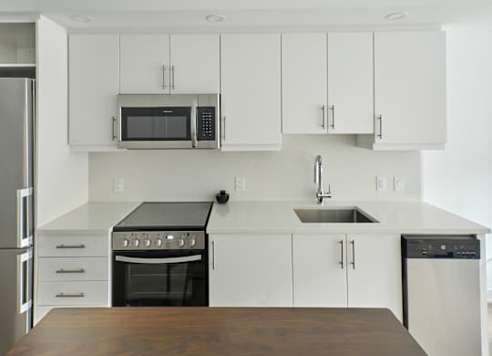 a kitchen with white cabinets and stainless steel appliances
