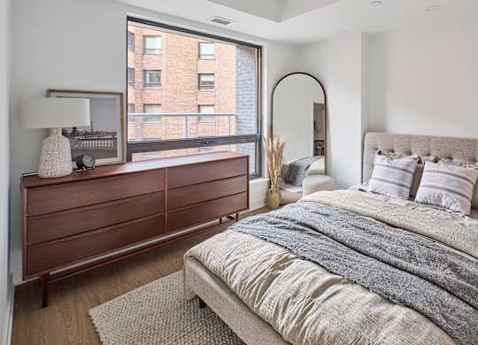 a bedroom with a bed and a large window