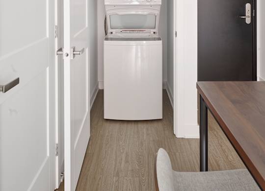 a small room with a refrigerator and a washing machine in it