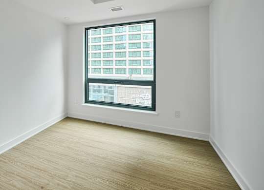 an empty room with white walls and a window