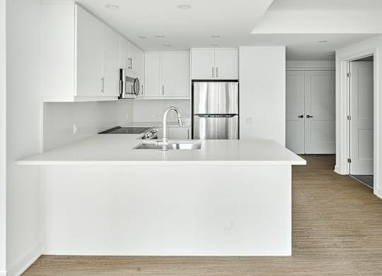 a large white kitchen with a white counter top and a white