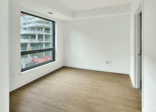 an empty room with white walls and a large window