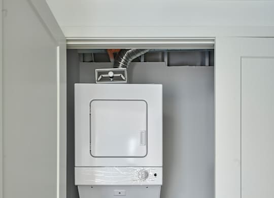a white washer and dryer in a white closet