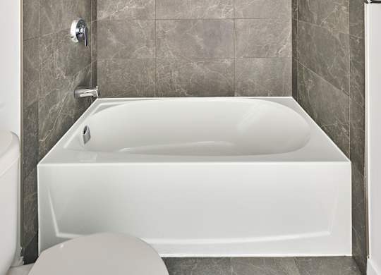 a bathroom with a white tub and a toilet