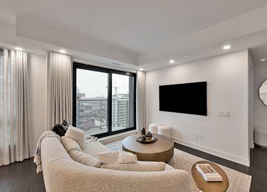 A modern living room with a large window and a flat screen TV.