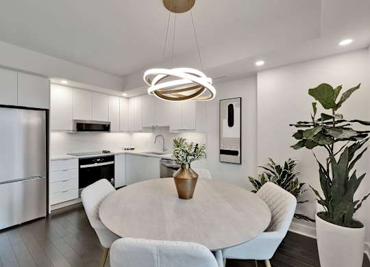 A modern kitchen with a dining table and chairs.