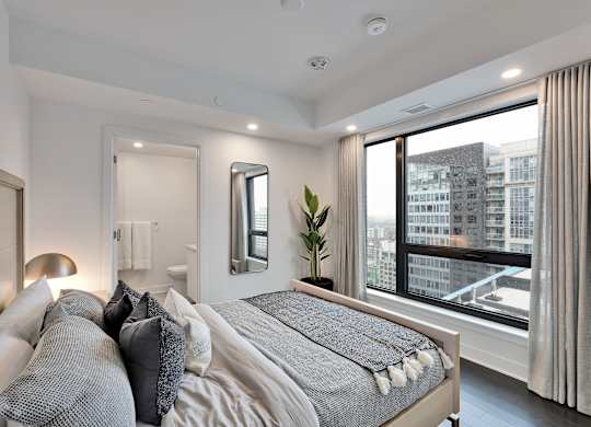 A bedroom with a large bed and a view of the city.