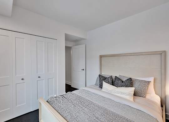 A bedroom with a bed, pillows, and a headboard.