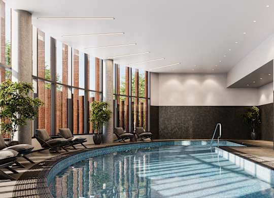 A large indoor swimming pool with lounge chairs and a sunken seating area.