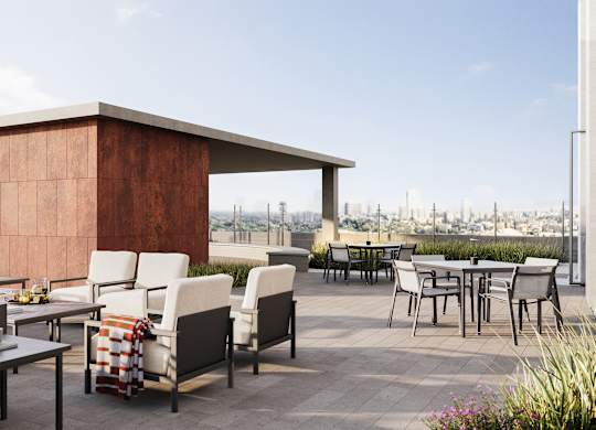 A patio with a table and chairs with a brown building in the background.